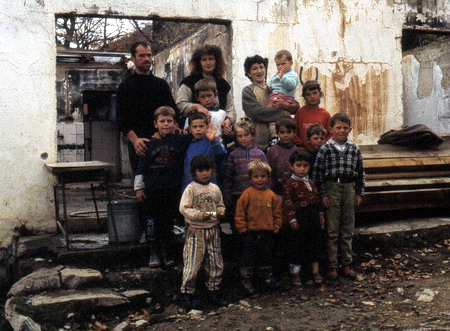 Mitrovia, Kosovo 2000: Zwei Familien mit verwaisten Kindern vor den Trümmern ihres Hauses Foto: Uwe Schütz