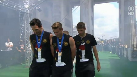 15.07.2014: Emfpang der Deutschen Fußball-Nationalmannschaft in Berlin. Spieler kommen mit dem Pokal durch das Brandenburger Tor 