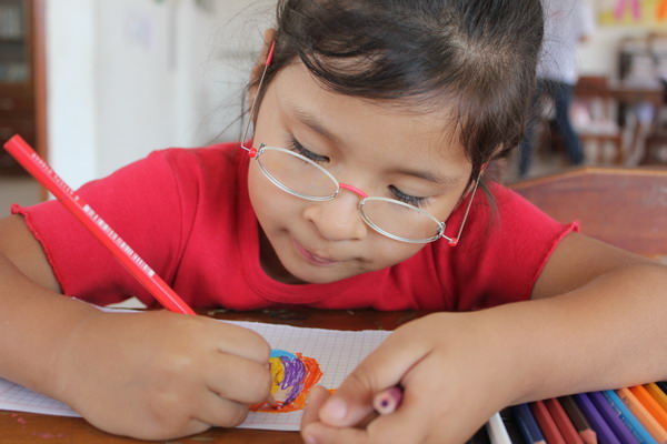 Mädchen in Bolivien mit Ein-Dollar-Brille.