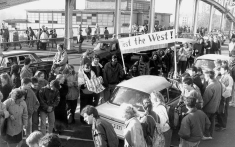 10.11.1989, der Tag danach in Berlin: Am geöffneten Grenzübergang Bornholmer Straße begrüßt eine Menschenmenge die Trabant-Fahrer mit dem Transparent "Test the West!"