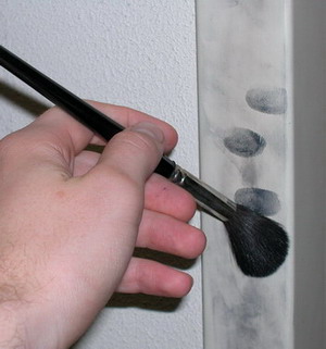 Sichtbarmachen von Fingerabdrücken mit einem schwarzen Puder 