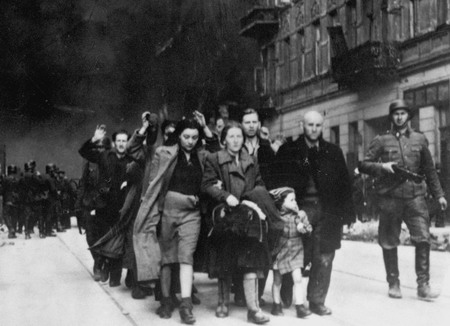 Mai 1943: Gefangene jüdische Bewohner des Ghettos in Warschau werden von der SS durch die brennenden Straßen abgeführt 