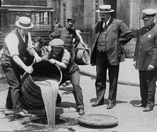 New York City während der Prohibition: Unter Polizeiaufsicht wird Wiskey in die Kanalisation entsorgt 
