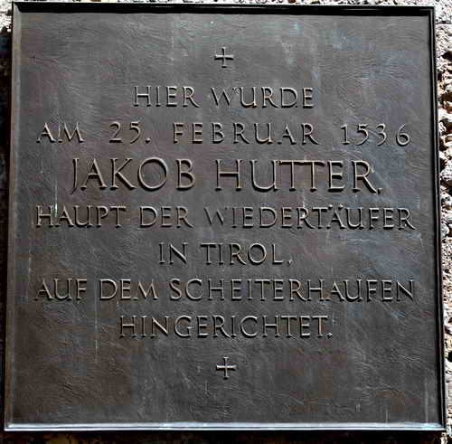 Gedenktafel-Iinschrift: „Hier wurde am 25. Februar 1536 Jakobh Hutter, Haupt der Wiedertäufer in Tirol, auf dem Scheiterhaufen hingerichtet.“ 