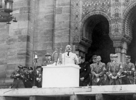 10.08.1938: Auf einer Großkundgebung am Nürnberger Hans-Sachs-Platz verkündet Gauleiter Julius Streicher den Abriss der Hauptsynagoge (im Hintergrund)